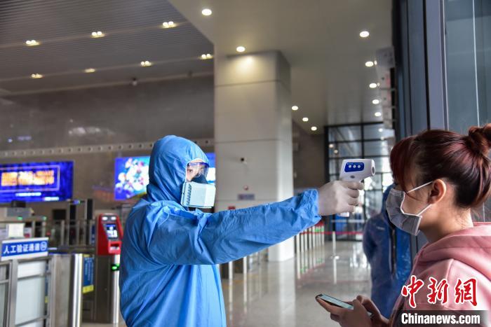 系统启用前，工作人员使用测温枪对旅客进行测温。　王以照 摄